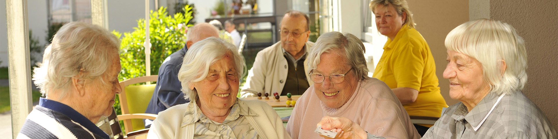 Senioren sitzen an einem Tisch zusammen