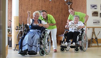 Frauen im Rollstuhl werden von AllgäuPflege-Mitarbeitern geschoben