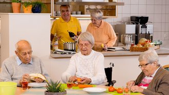 Senioren sitzen am Tisch in einer Einrichtung des Betreuten Wohnens der AllgäuPflege