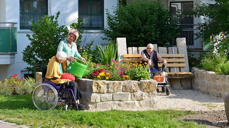 Senioren sitzen im Garten der stationären Einrichtung der AllgäuPflege in Altusried