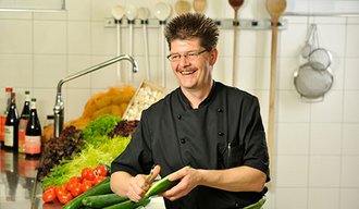 Ein Mann kocht in der Küche der AllgäuPflege